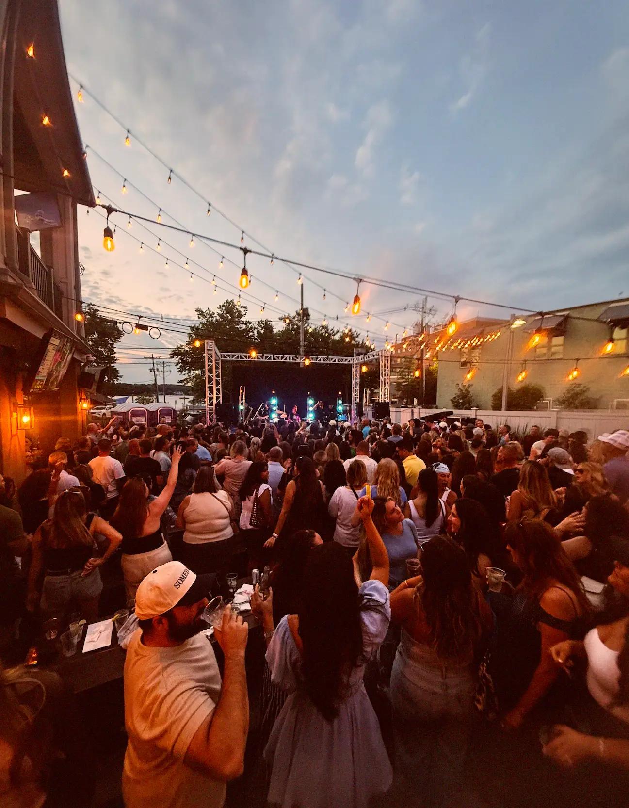 A Class Kills crowd in front of an outdoor stage at dusk
