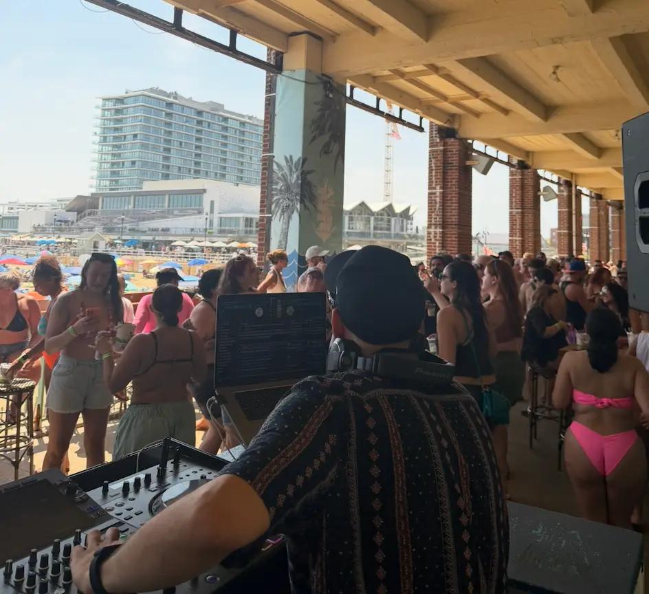 A Class Kills DJ performing for a beachfront crowd